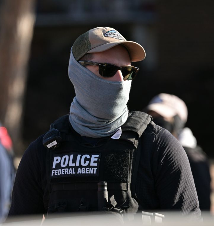 A masked ICE agent, wearing a balaclava