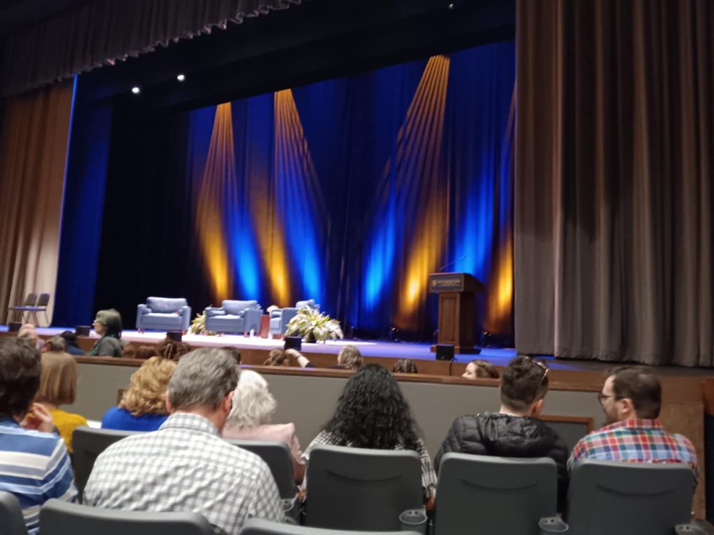A stage with gold and blue lights shining on it. There are only two rows separating me from the 'orchestra pit' section, where there were only three rows of seats, maybe? The stage has a podium and three empty chairs, plus a few plants.

It's the only photo I took when we went to see LeVar Burton, which was amazing, and I cannot remember if I rambled about it in February.
(They asked for no photos, or I would have taken a billion. No, I didn't cheat and take one anyway, like one of the women ahead of us who then spent an unnecessary amount of time bitching about getting called out by a worker for it.)