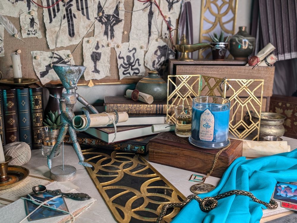 Photo set for a Neve Gallus inspired soy candle. It features a red string conspiracy board from Dragon Age, art deco elements and books for decoration. 