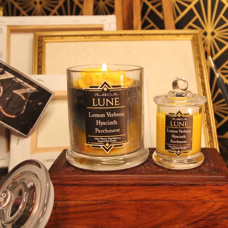 Our Lune inspired candle in both large and small sizes. The label reads "Planeshift Candles. Lune, Lemon Verbena, Hyacinth, Parchment. Clair Obscur Expedition 33 inspired candles" 