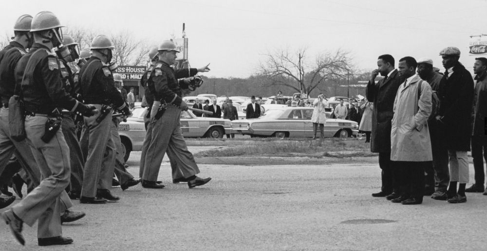 On Mary 7, 1965, 600 civil rights protesters attempted a march from Selma to Montgomery, Alabama, the state capital, to draw attention to the voting rights issue. Led by Hosea Williams (at right front in dark raincoat) and John Lewis (at right in light colored coat), the marchers crossed the Edmund Pettus Bridge over the Alabama River on their way to Montgomery. There they encountered Alabama state troopers and local police officers who gave them a two-minute warning to stop and turn back. When the protesters refused, the officers tear-gassed and beat them. Over 50 people were hospitalized. Photo taken by Spider Martin. National Archives photo (National Archives Identifier 16899041)