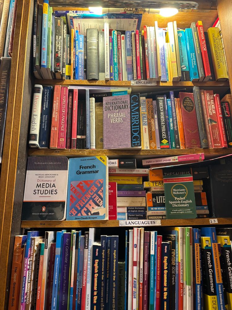 A bookshelf in the Abbey Bookshop in Paris showing Benjamin Dreyer's "Dreyer's English" in the reference section.