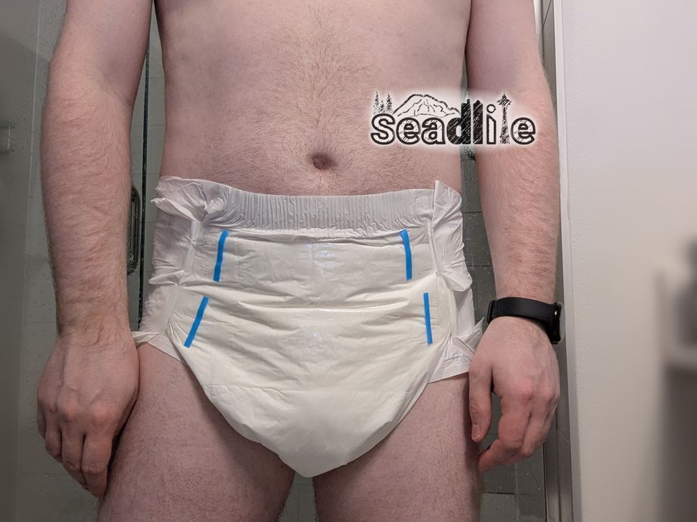 a man standing wearing a white MEGAMAX diaper and a black watch