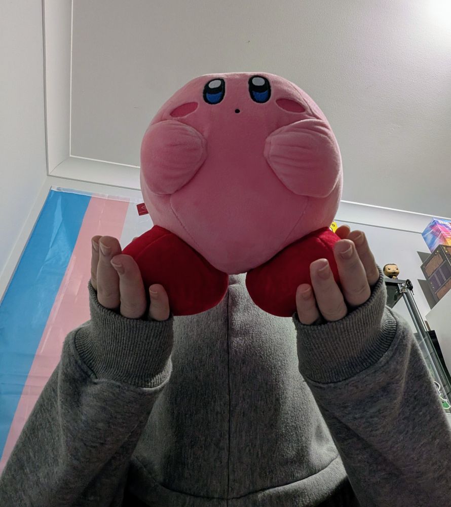 Revy bowing and holding up a Kirby plushie into the air