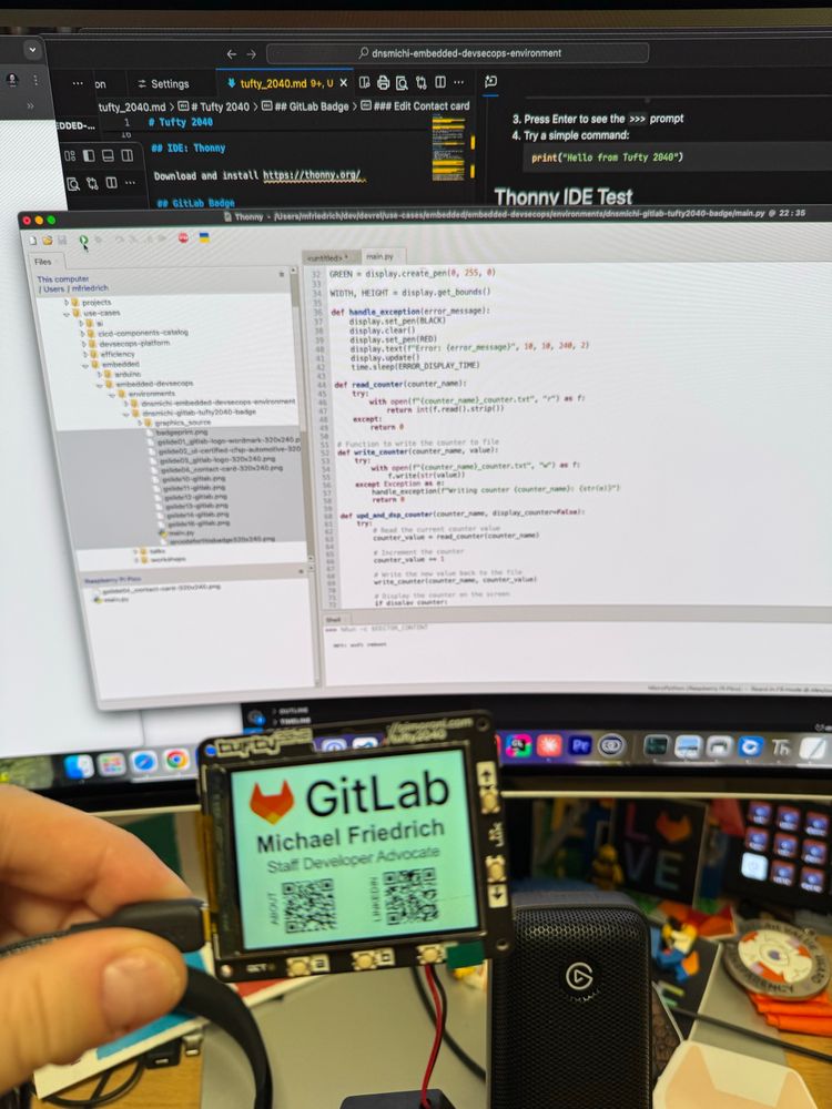 Tufty 2040 display, showing the GitLab logo, Michael Friedrich, Staff Developer Advocate, and 2 QR codes with About and LinkedIn.

Background: monitor with Thonny IDE and Micropython code to provision