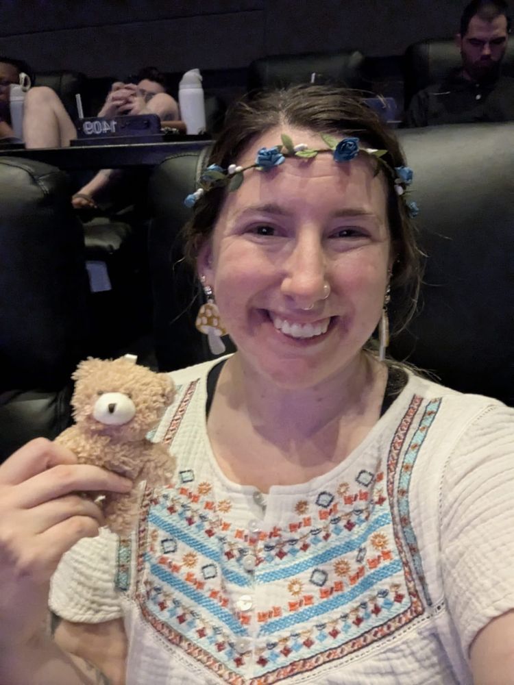 Erica posing and smiling with her little bear and her flower crown
