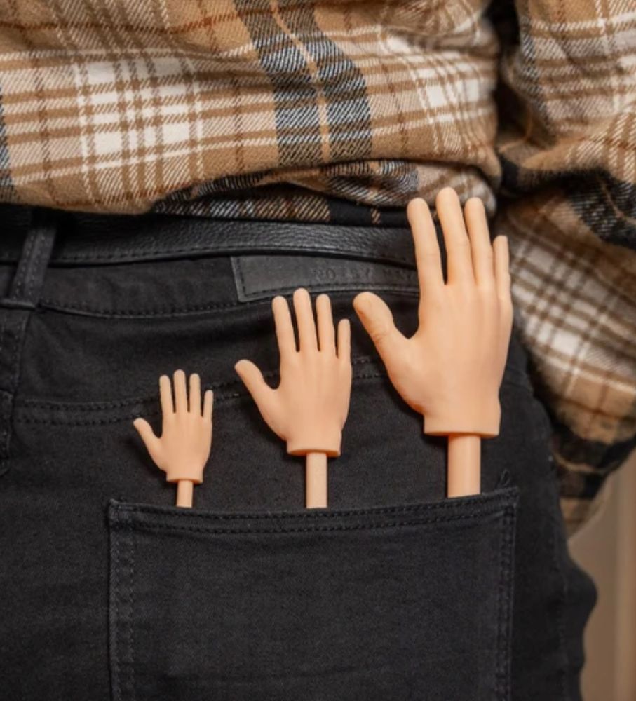 Tiny plastic hands on a stick in three different sizes stuck into back pocket. Ready to pet a cat without having your hand shredded. 