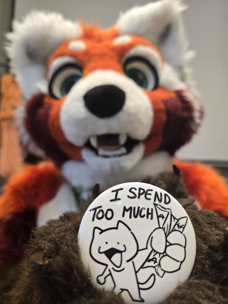Silly red panda furry holding up a pin saying "I spend too much"