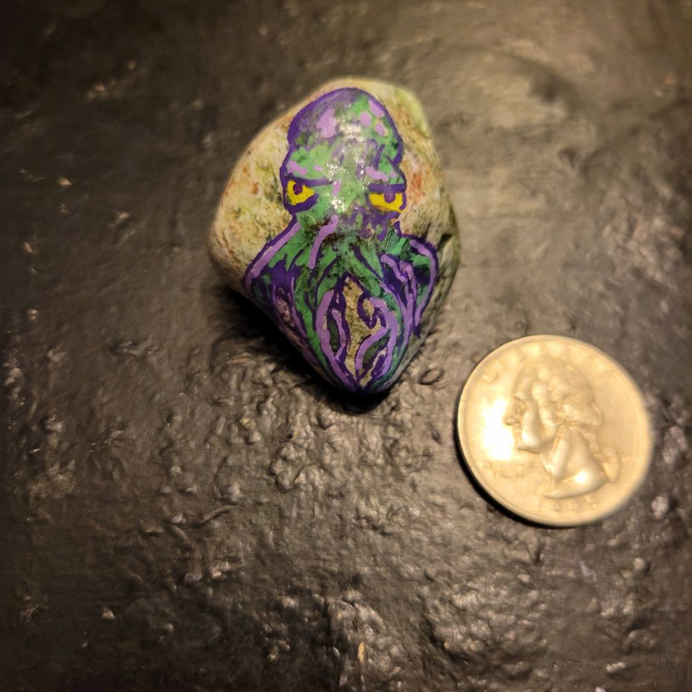 The rock is kind of greenish with some orange bits. There's an annoyed looking octopus with yellow eyes. He's outlined in purple, mostly green, with some lavender streaks. 

The tentacles kind of got away from me, honestly. As you can see in the other photos, there weren't enough legs to start with, but then I went a little crazy overcompensating. Just legs everywhere. He's probably technically more of a Chthulian Horror than an octopus at this point, but he looks pretty badass.