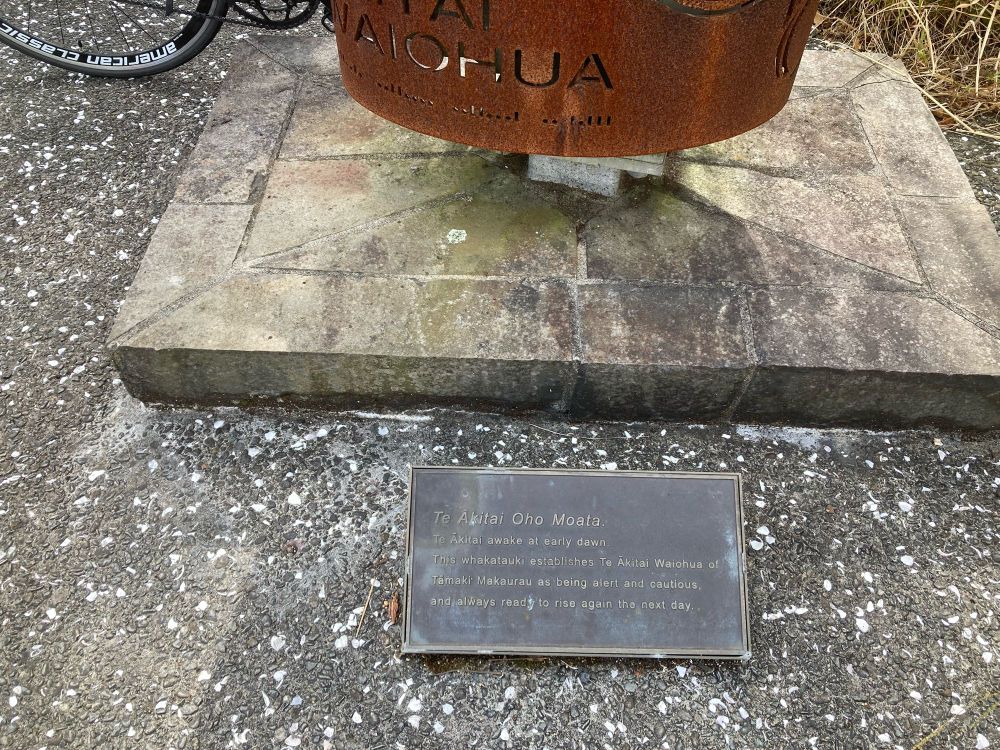 Plaque at base of Te Ākitai Oho Moata, a sculpture on the Waterview Shared Path with inscription “Te Ākitai awake at early dawn. This whakatauki establishes Te Ākitai Waiohua of Tamaki Makaurau as being alert and cautious and always ready to rise again the next day”