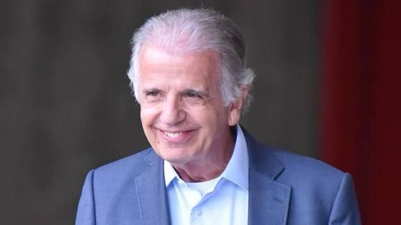 Foto do ministro da defesa José Múcio, homem idoso com cabelo grisalho, veste camisa branca e paletó azul, está com o sorriso cínico de um bom filha da puta safado acobertador de milico pilantra.