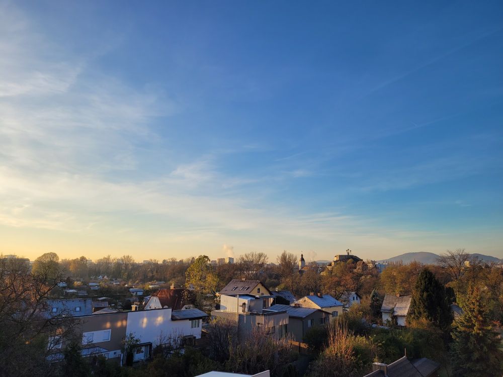 Photo showing houses in the autumnal morning light with a blue sky