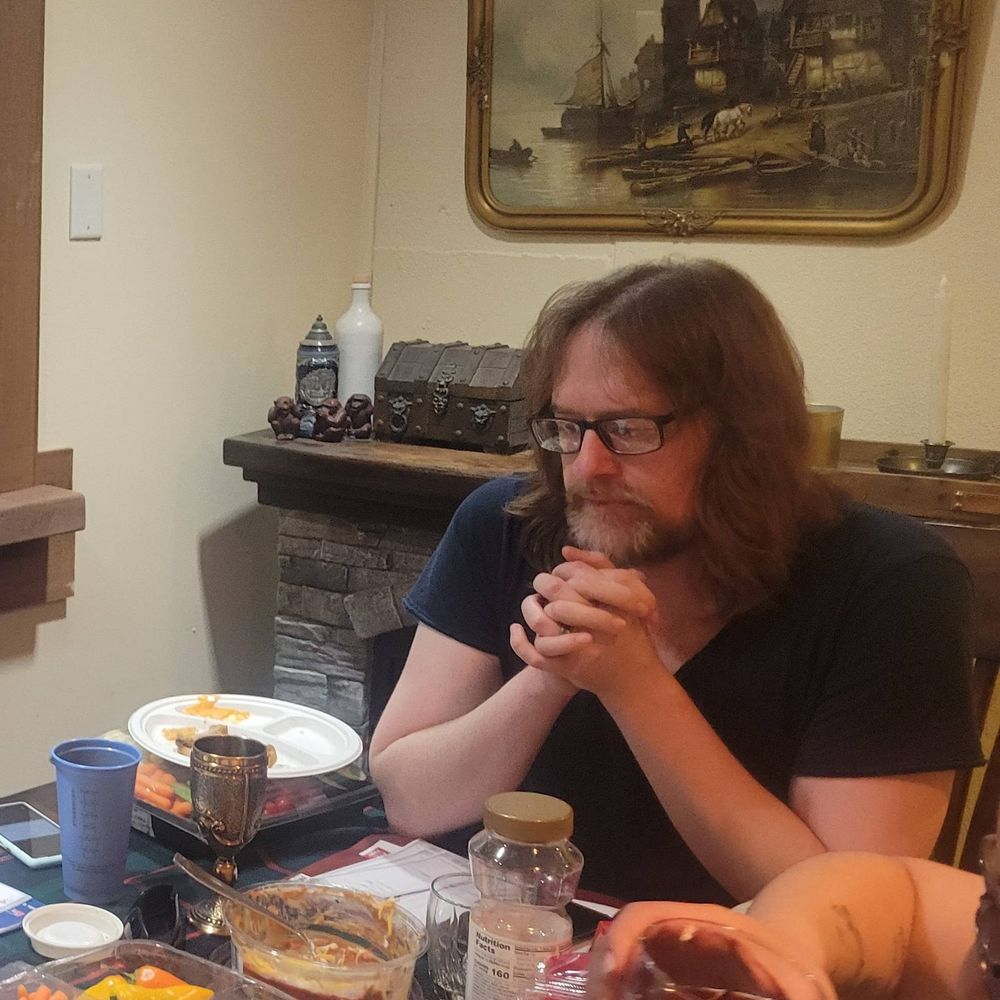 Adam sits at the gaming table contemplating his next move.  Or perhaps he is contemplating the bean dip.  