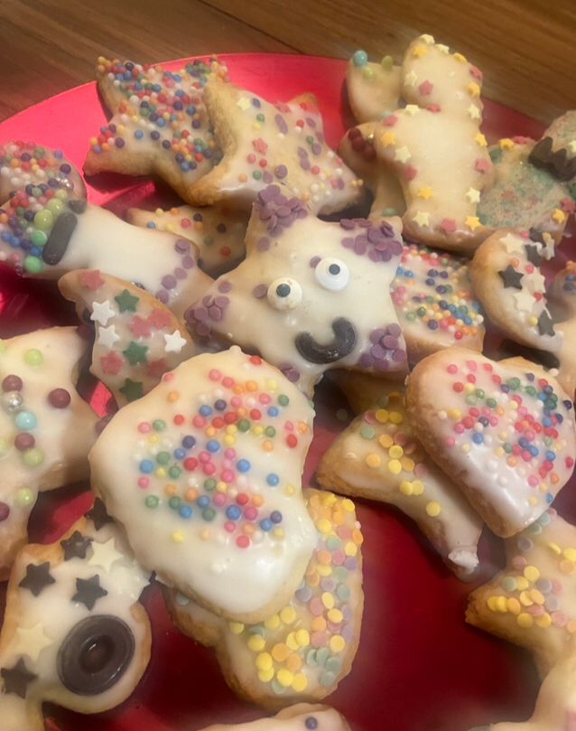 Plätzchen in Herzen-, Sterne-, Mond- und Sandmännchenform- mit Zuckerhuss überzogen und bunt dekoriert