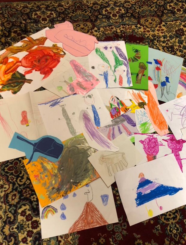 Viele Kleinkinderzeichnungen in allen erdenklichen Formen und Farben und Stilen liegen random angeordnet zusammen auf nem hauptsächlich dunkelrot-beige-dunkelgrün gemusterten Teppich