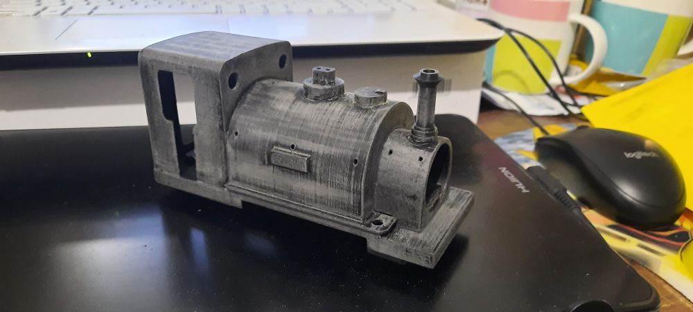 Image of a 3d printed bodyshell of a thomas the tank engine train character named duke, he is sitting on a graphics tablet