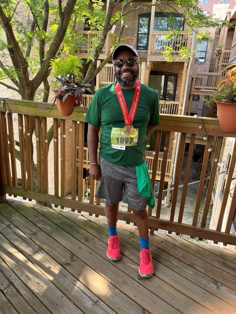 A very proud black man wearing his newly acquired medal around his neck. 