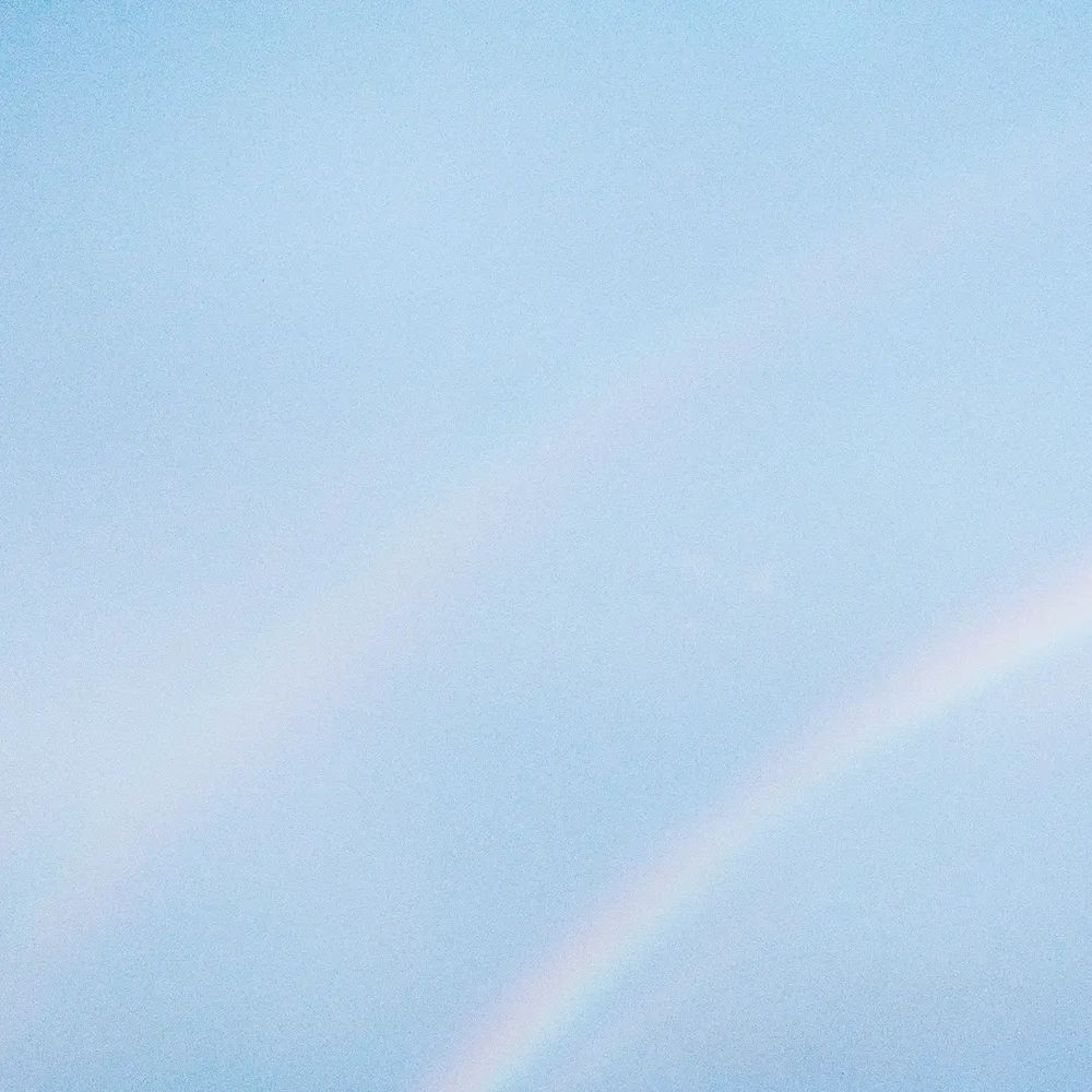 Turnstile – Never Enough
Soft sky blue cover featuring faint pastel rainbow arcs with no visible text, creating a calm washed out effect.