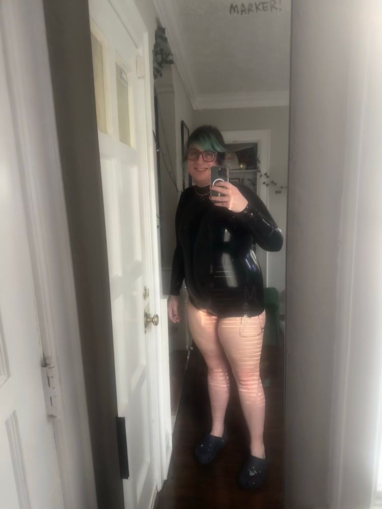 Woman in latex bodysuit and blue crocs