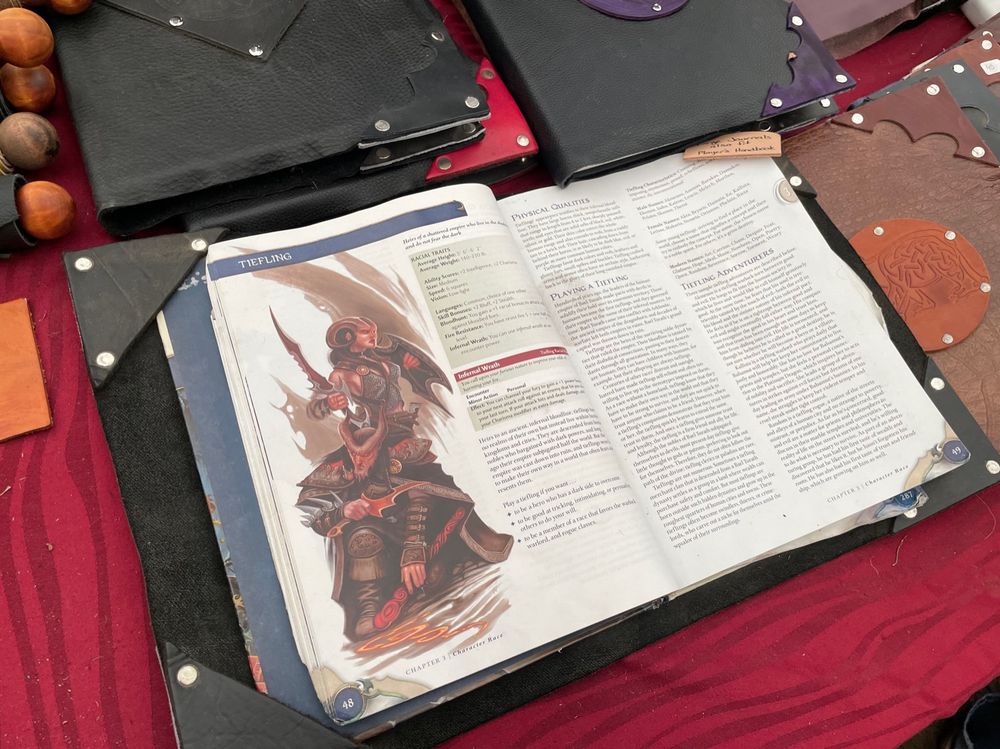 A 4th edition D&D Player’s Handbook inside a leather book cover.