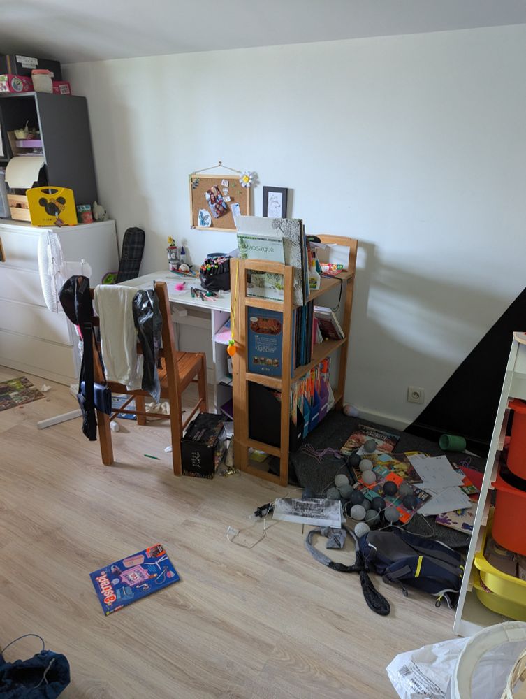 Chambre de la mini bis : des papiers sous le bureau, et son coin lecture impraticable : magazines, sac à dos, guirlande... Tout est par terre)