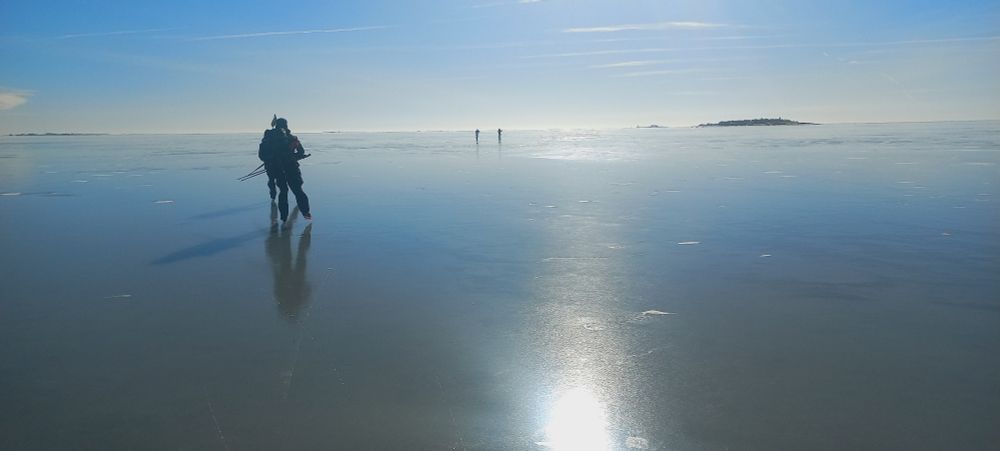 Retkiluistelijoita täydellisen sileällä merenjäällä Helsingin edustalla