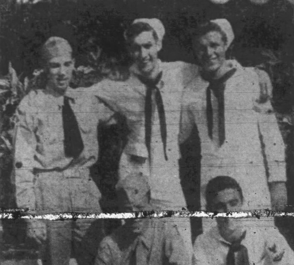 Five military members, 3 standing (in Naval attire), 2 seated (cropped off)