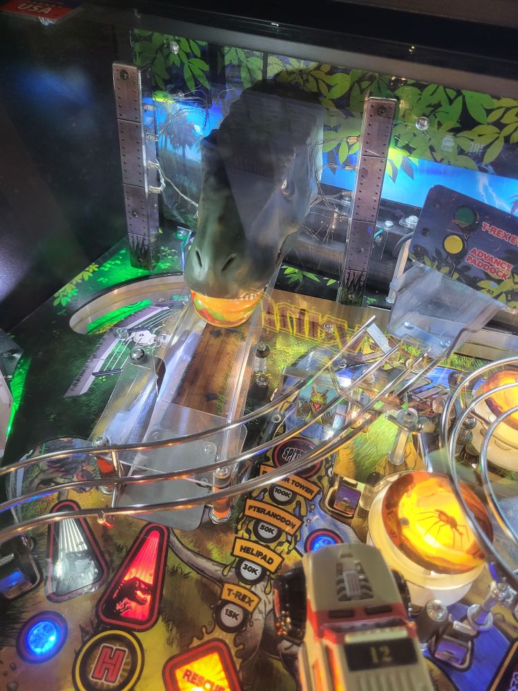 jurassic park pinball. the t-rex has a big plastic cheeseburger in its mouth.