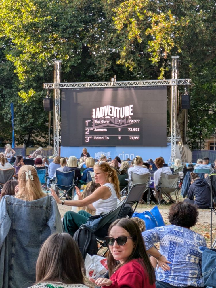 A screen in the distance displays the results of the pre-film quiz. 