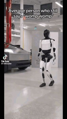 a robot is walking in a garage and says womp womp