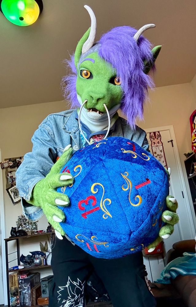 A picture of me wearing my new fursuit of my fursona Astoria holding a d20!