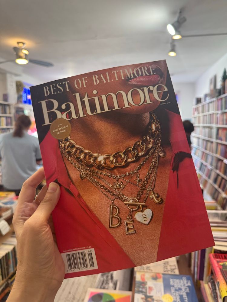 A hand holding up Baltimore Magazine’s Best of Baltimore issue (their 50th!)