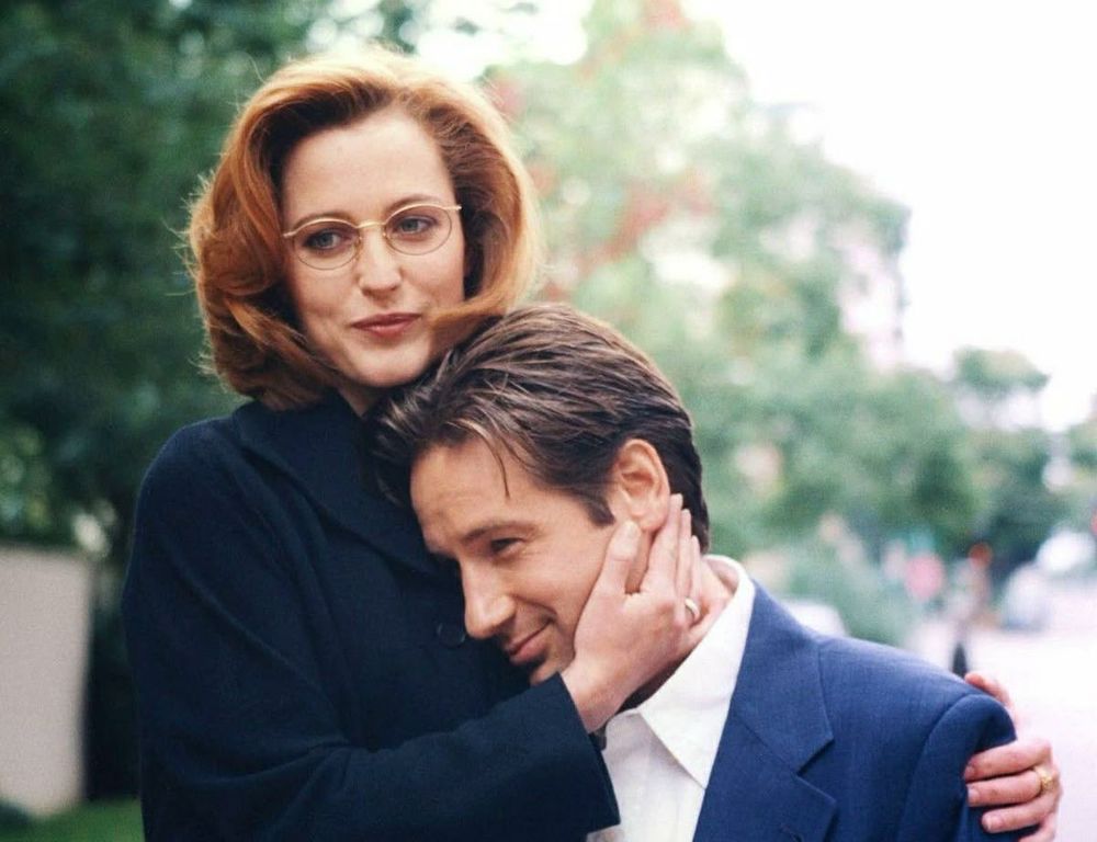Agents Scully & Mulder, softly smiling and warmly embracing. 