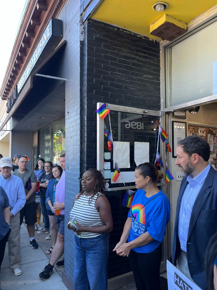 Kanessa, owner of Perfect 10 Salon in West Roxbury, speaks in front of her store as Councilors Mejia and Weber and attendees listen.