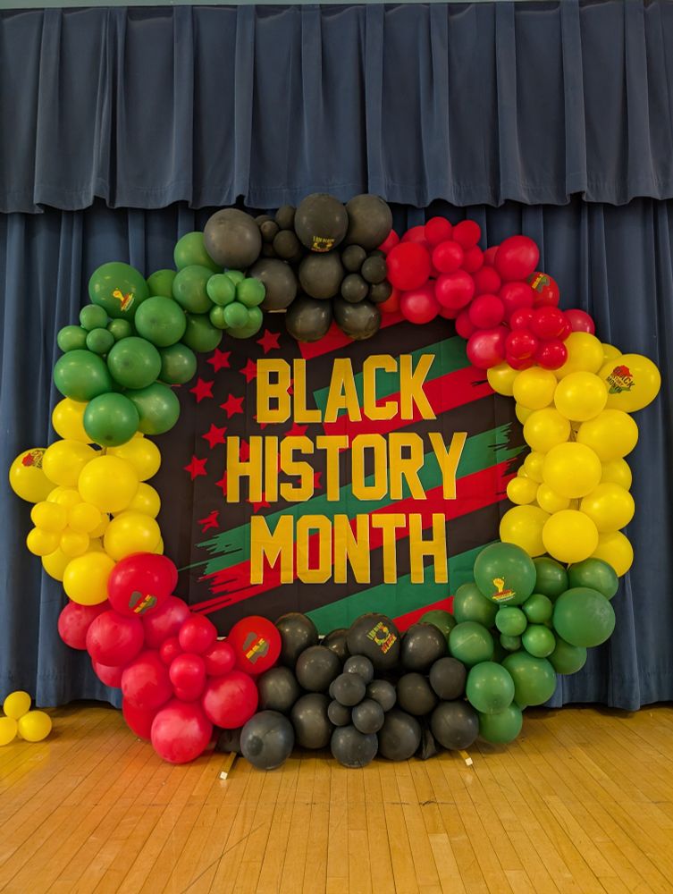 Black History Month sign and balloon arch. 