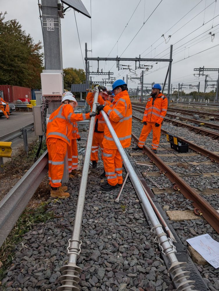A group of people in hi Viz constructing a cantilever on track