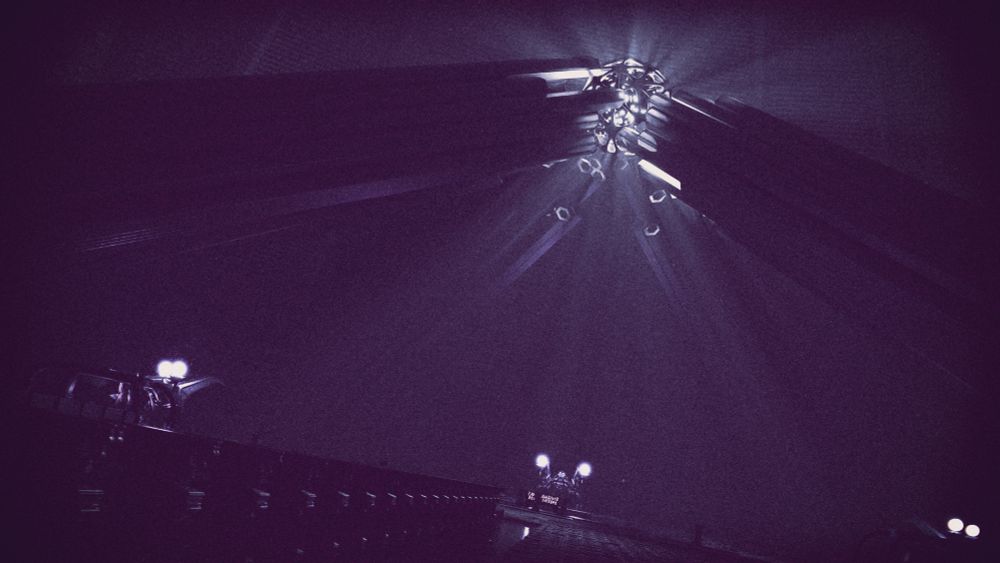 A vast room with a weird glowing orb above, and a few statues seemingly holding more glowing orbs up.