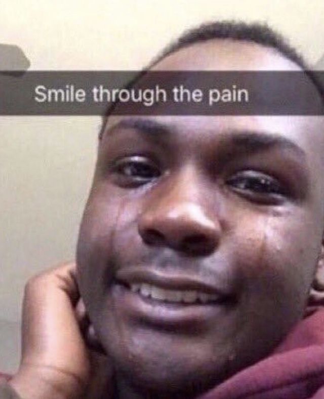 A person smiling with tears down their face and a caption that reads "smille through the pain"