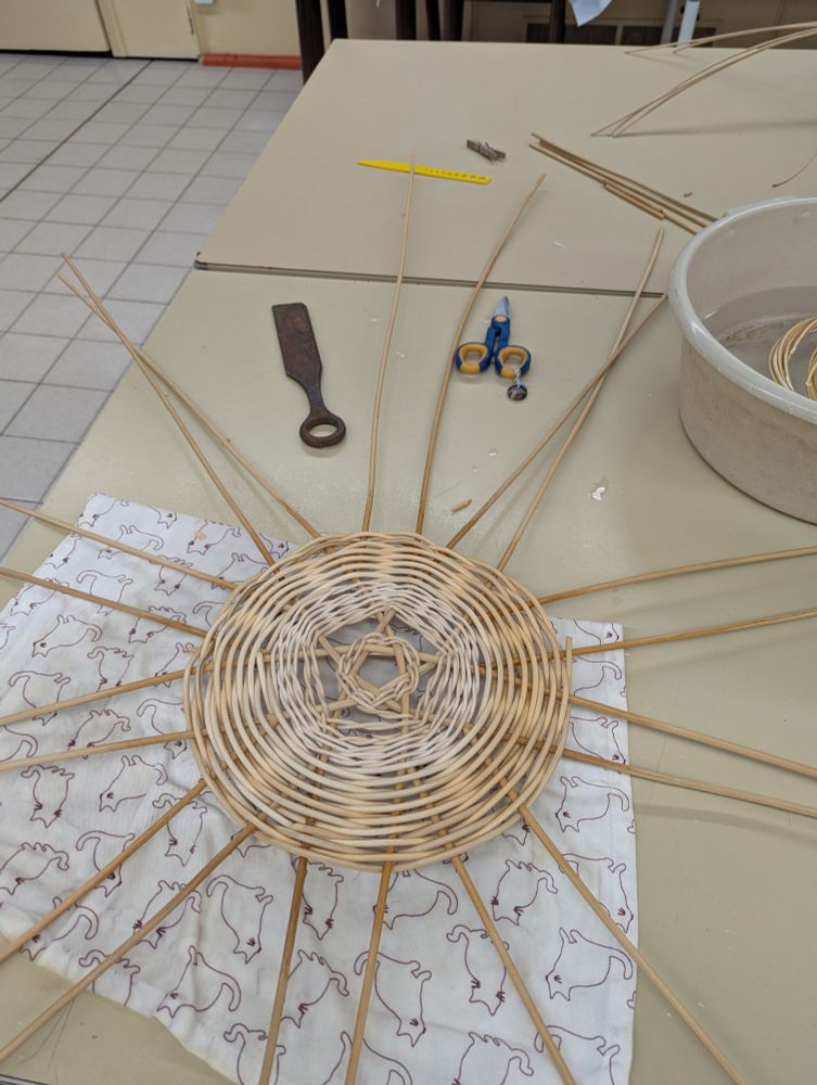 Une base de corbeille en rotin, sur une croisée en étoile à cinq branches 