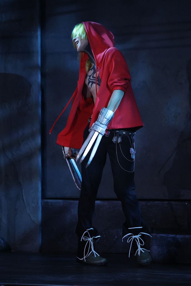 Photo of stage Gunji twisting around with his head to the side, presumably saying something to someone offscreen