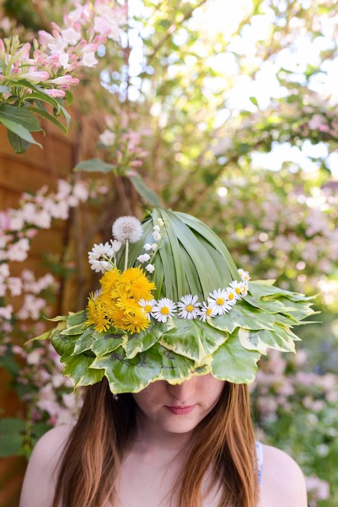 Young woman wearing a Sunday made of leaves and spring flowers.