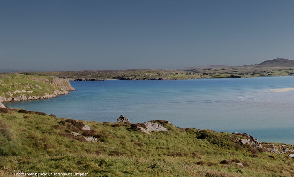 Blue sea and a rocky, grassy coastline