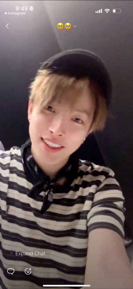 Hongjoong smiling more fully at the camera, his face unobstructed and medium brown hair slightly frizzy and unstyled. 