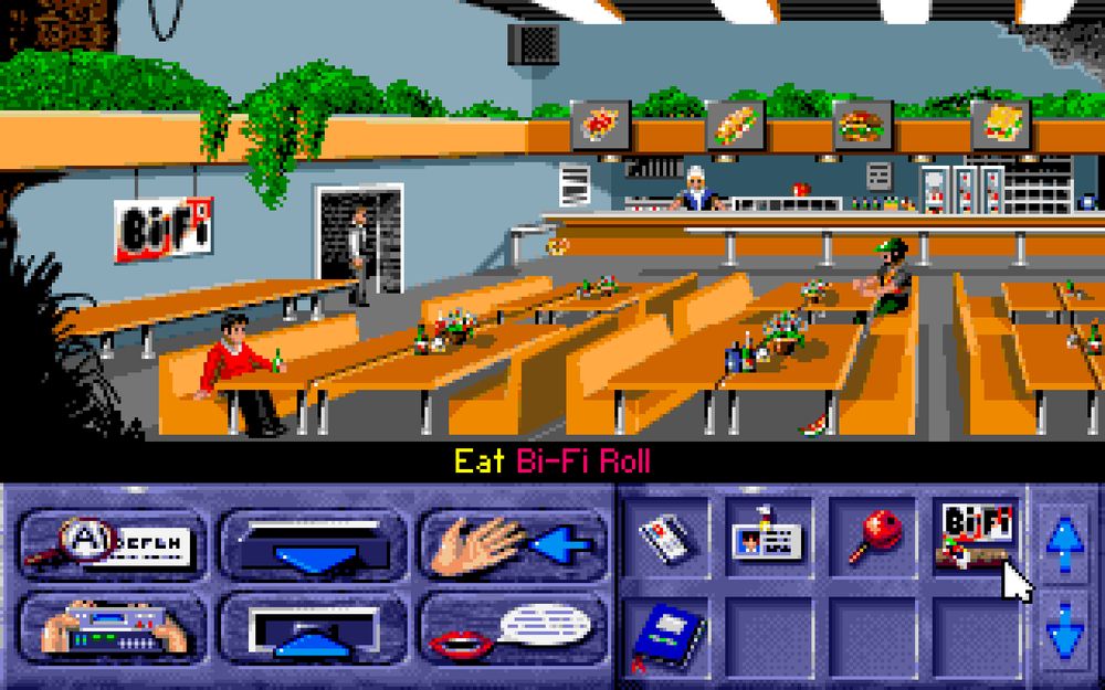 A scene from "Bi-Fi: Action in Hollywood". Lukas is standing in the doorway of the studio cafeteria. A couple of people are seated on the tables. The mouse cursor is hovering over a Bi-Fi Roll in the player's inventory and the action line reads "Eat Bi-Fi Roll".