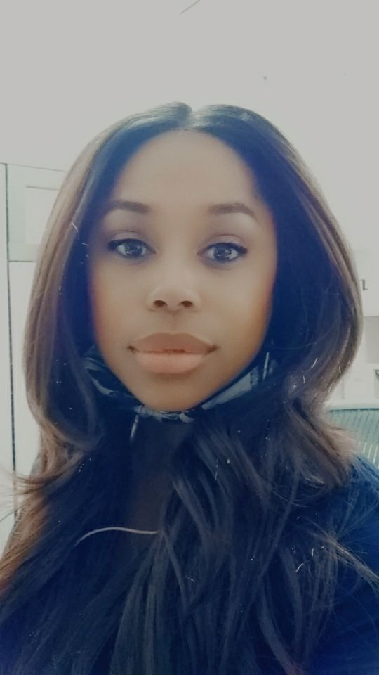 A woman with a mask under her chin smiles