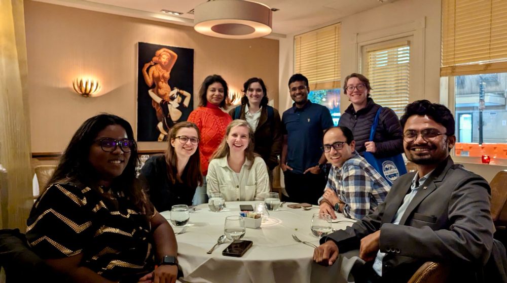 A group of people happily posing inside a restaurant.