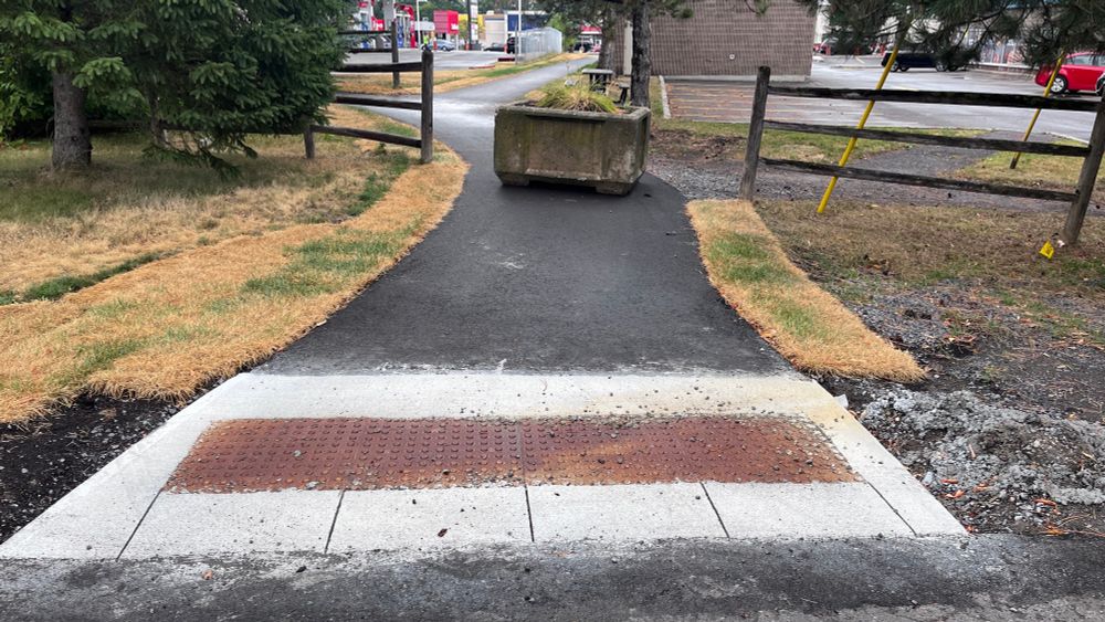 A planter is sitting in the middle of a pathway 