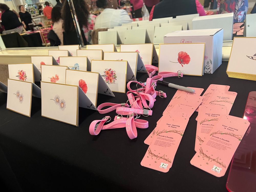 Party favors table at the brunch! Personalized cards with florals, pink lanyards keychains and Pen Your Journey custom bookmarks 