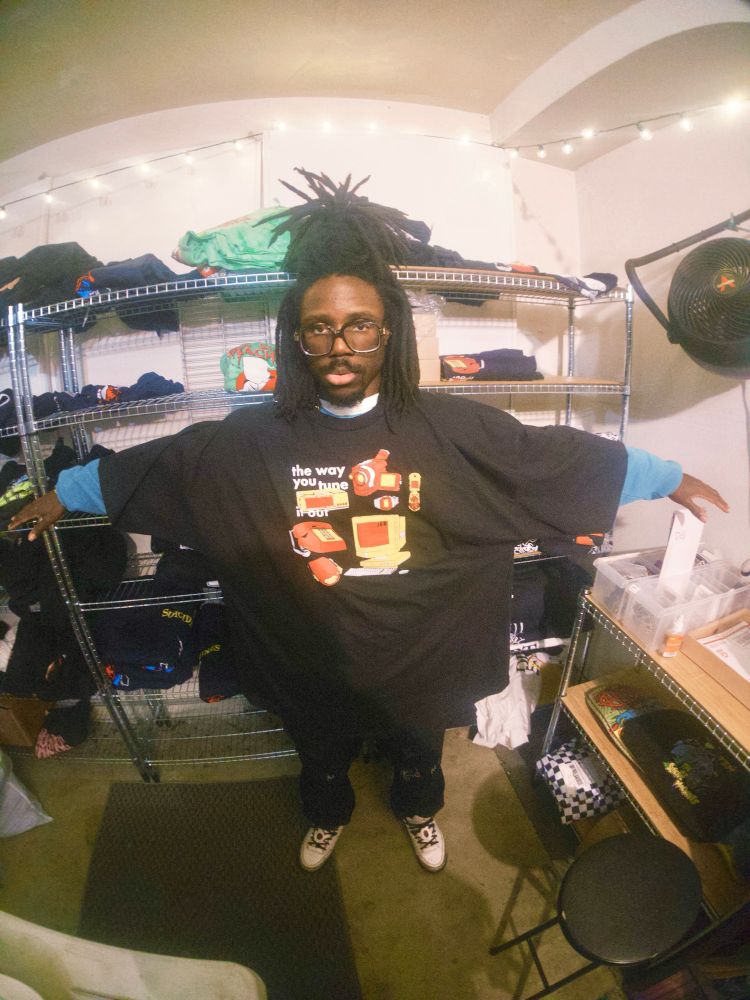 JER wearing a 5XL tune it out shirt with their arms up. 