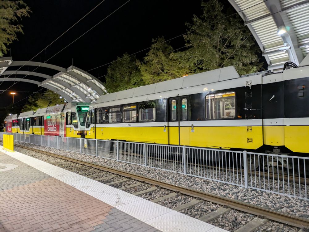 A picture of DART's light rail with the surrounding Trinity Mills station.